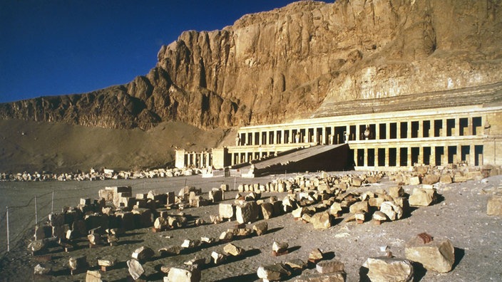 Blick auf den Tempel der Königin Hatschepsut unterhalb des felsigen Wüstengebirges in Luxor.