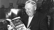 Ludwig Erhard liest in seinem eigenen Buch