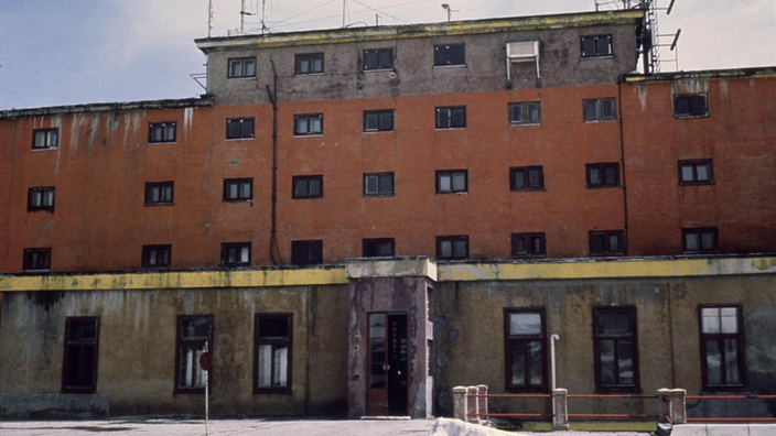 Rotes mehrstöckiges Gebäude mit heruntergekommener Fassade