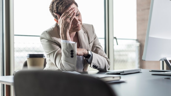 Eine erschöpfte Geschäftsfrau in einem Büro