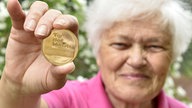 Bärbel Wohlleben zeigt die Medaille zum "Tor des Monats"