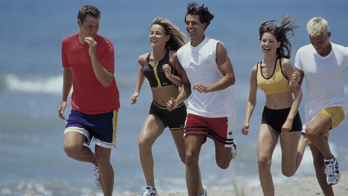 Ein Gruppe gut gelaunter Läufer am Strand.