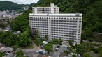 Ein weißer Hochhaus-Friedhof an einem grün bewachsenen Berg