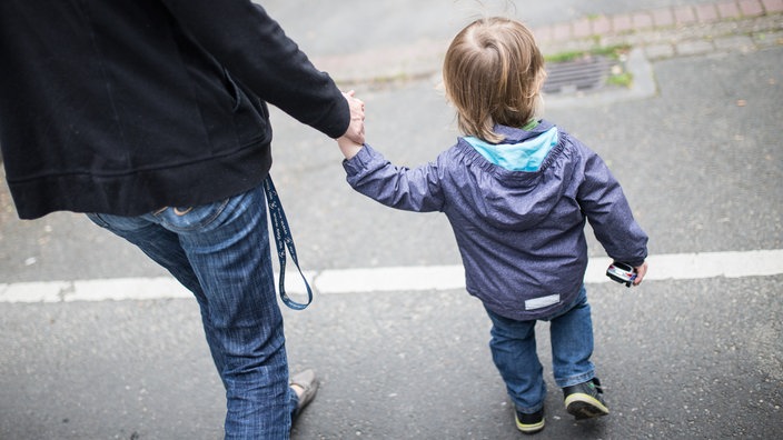 Mutter geht mit Sohn an der Hand 