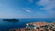 Blick über die Altstadt von Dubrovnik auf das Meer und eine vorgelagerte Insel.