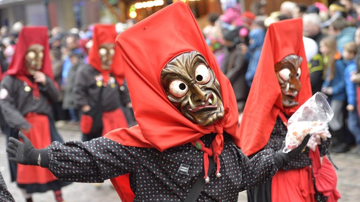 Bei einem Ronsenmontagsumzug gehen zwei traditionell verkleidete Narren mit 