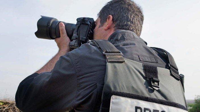 Ein Journalist fotografiert im Krisengebiet