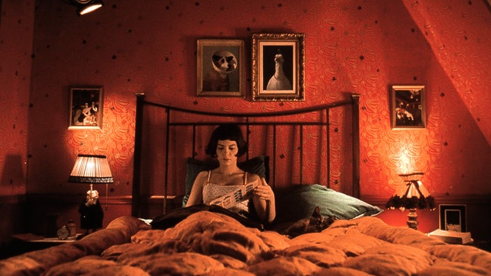 Amélie sitzt in der Filmszene in ihrem Bett und liest.