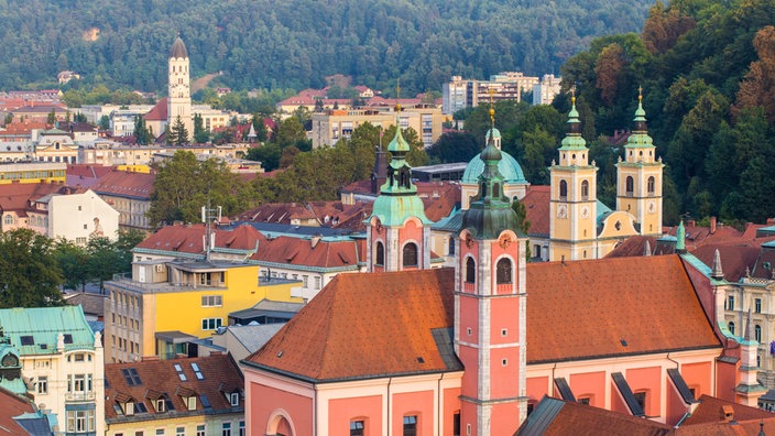 Blick auf die Dächer der Altstadt Ljubljanas, im Vordergrund eine Kirche