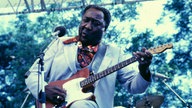 Muddy Waters mit Gitarre bei einem Konzert 1981.