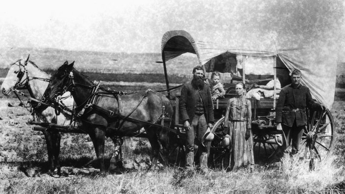 SW-Bild. Familie vor Planwagen