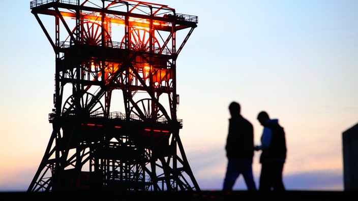 Zwei Arbeiter vor Förderturm des Gelsenkircheners Schachts Consolidation.