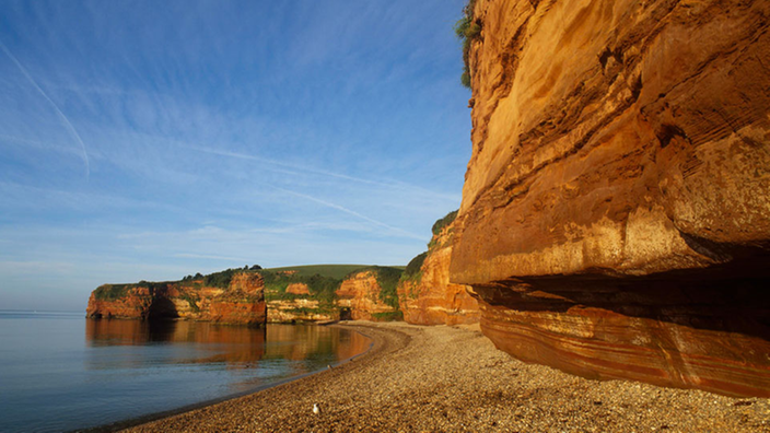 Das Bild zeigt einen roten Felsen im Meer.