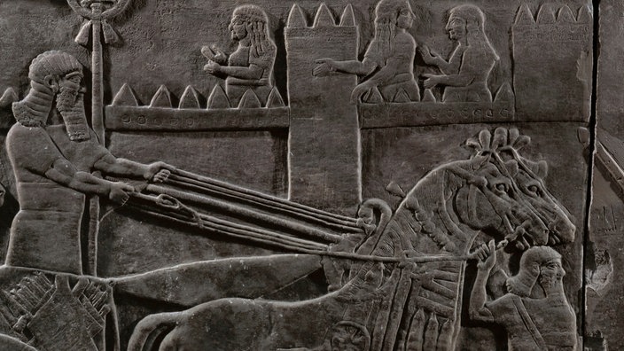 Steinrelief vom Palast in Nimrud: Pferdegespann vor einer Stadtmauer