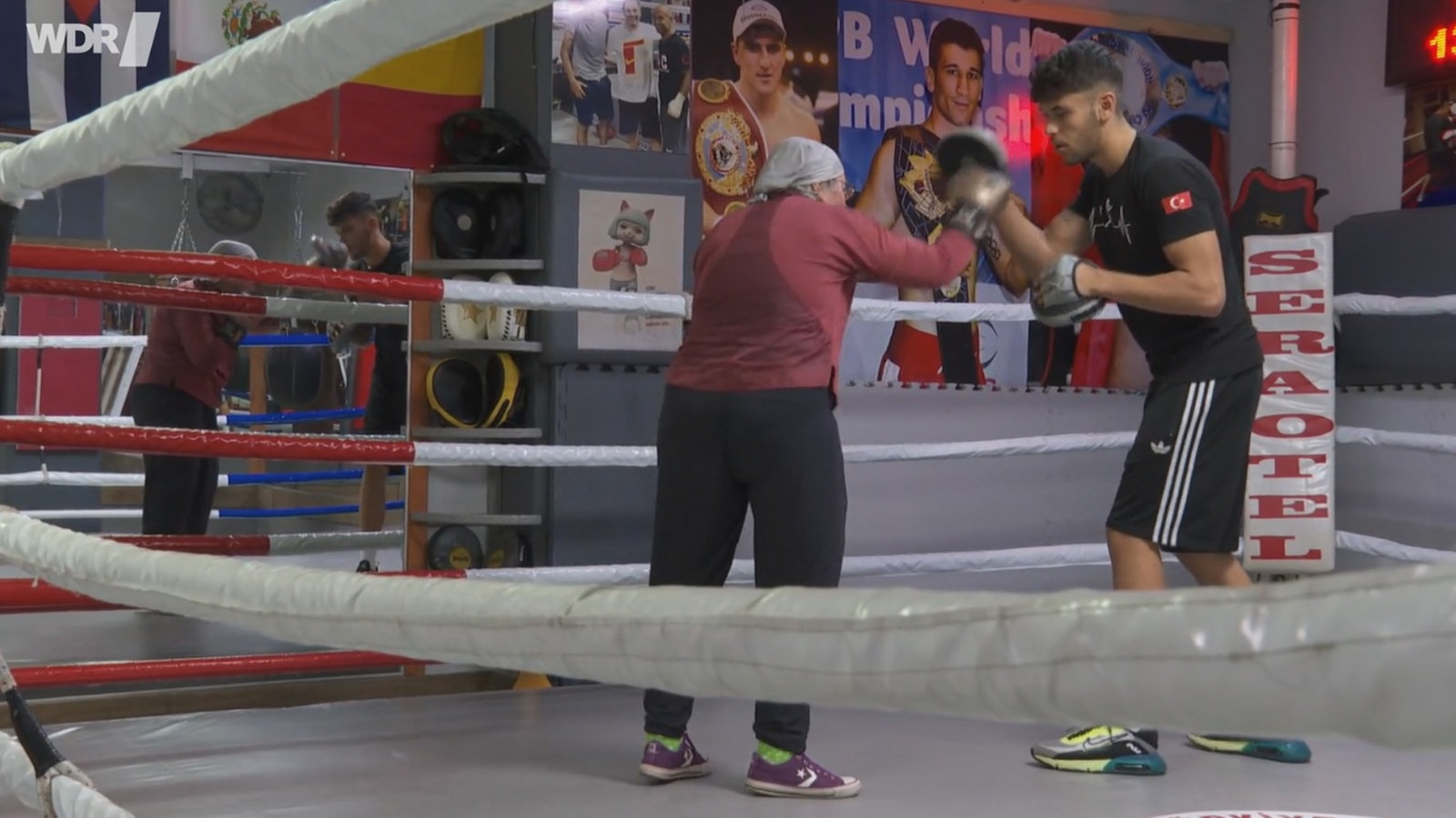 Eine ältere Frau von hinten im Boxring