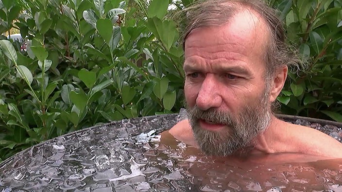 Ein Mann in einem Fass mit Eiswasser.